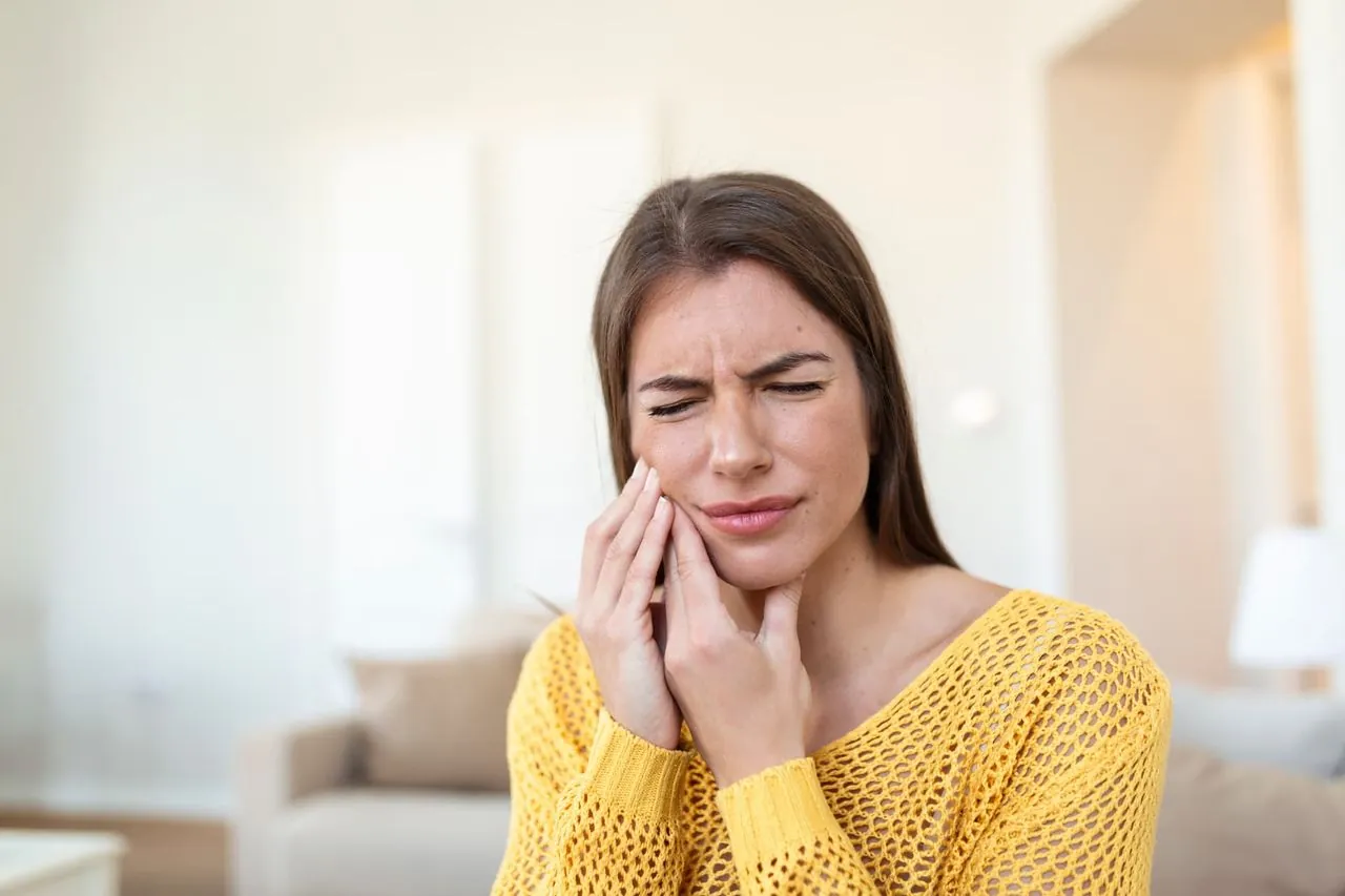Woman holding her cheek with toothache