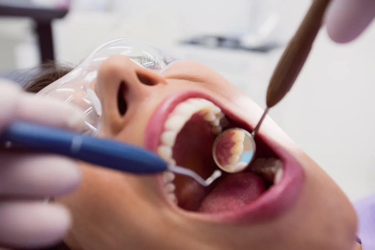 Dentist examining a patient's teeth with a mirror before a filling