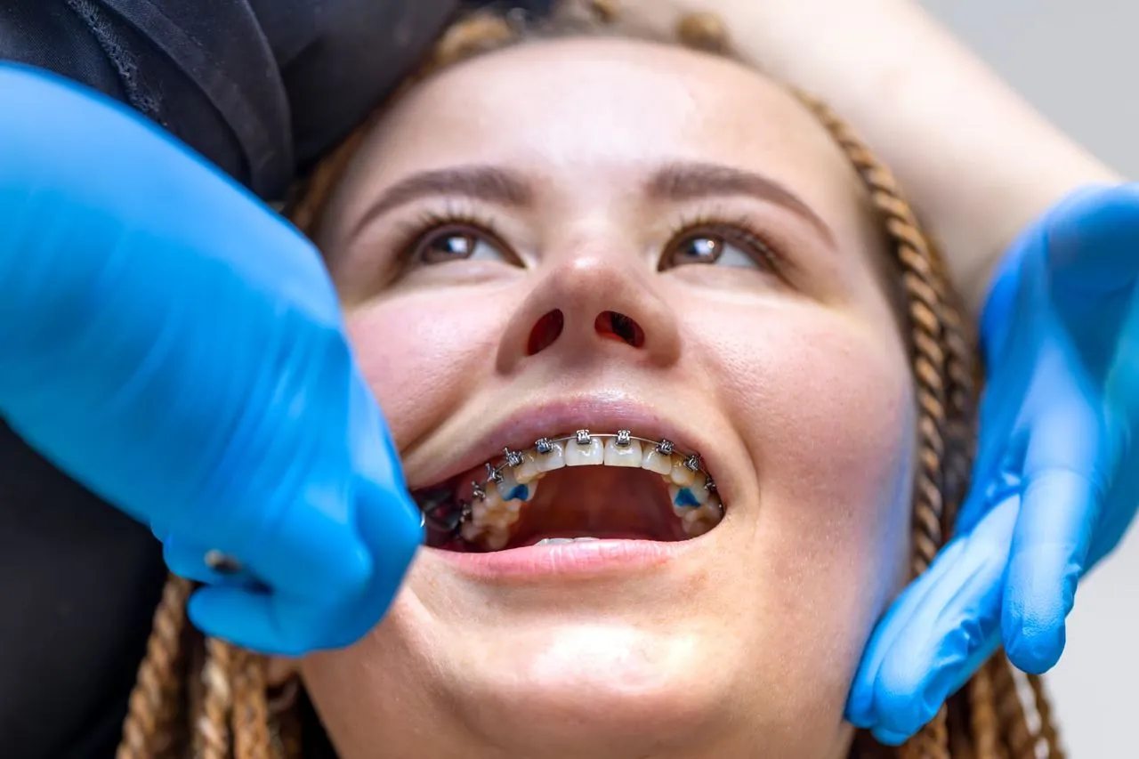 Orthodontist examining a patient's braces